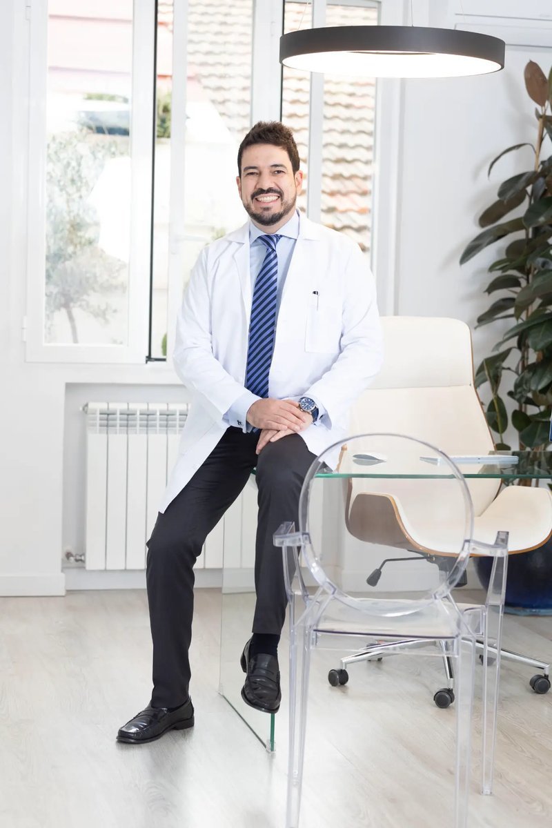 Dr. Jorge Duque sentado en consulta con bata blanca